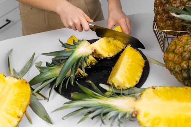 woman cutting pineapples on table