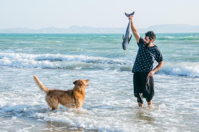 Man Playing with a Dog on a Beach