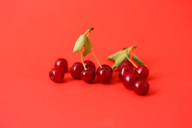 Sweet Cherries on red background